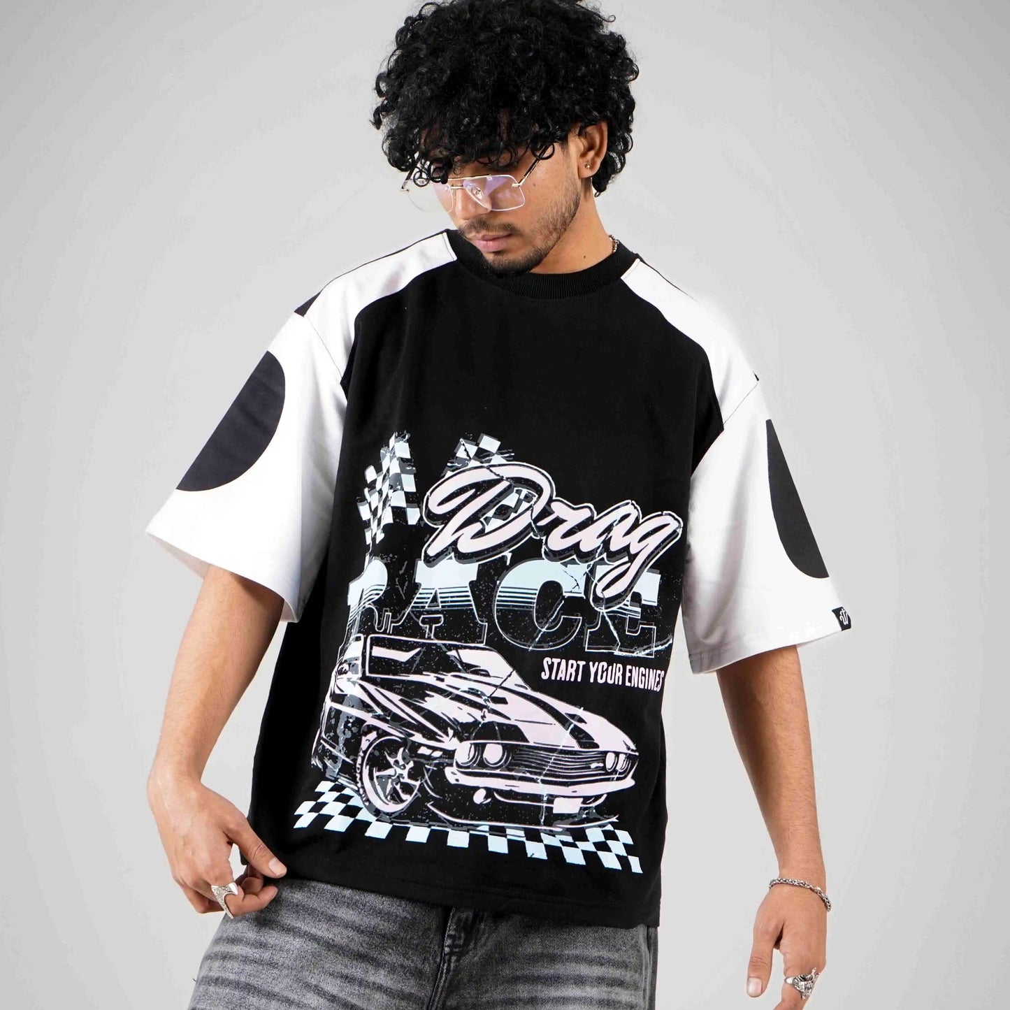 Model wearing black and white boxy fit t-shirt with car racing design by wibrnt